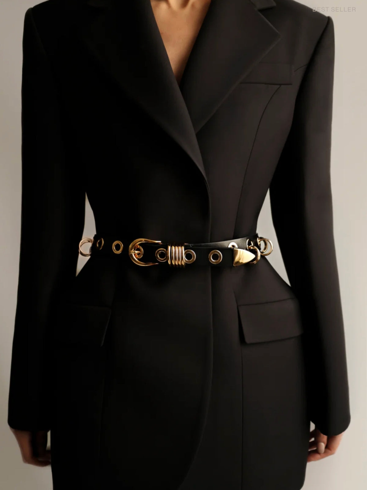 Déhanche Revenge black and gold belt worn at the waist over a black blazer