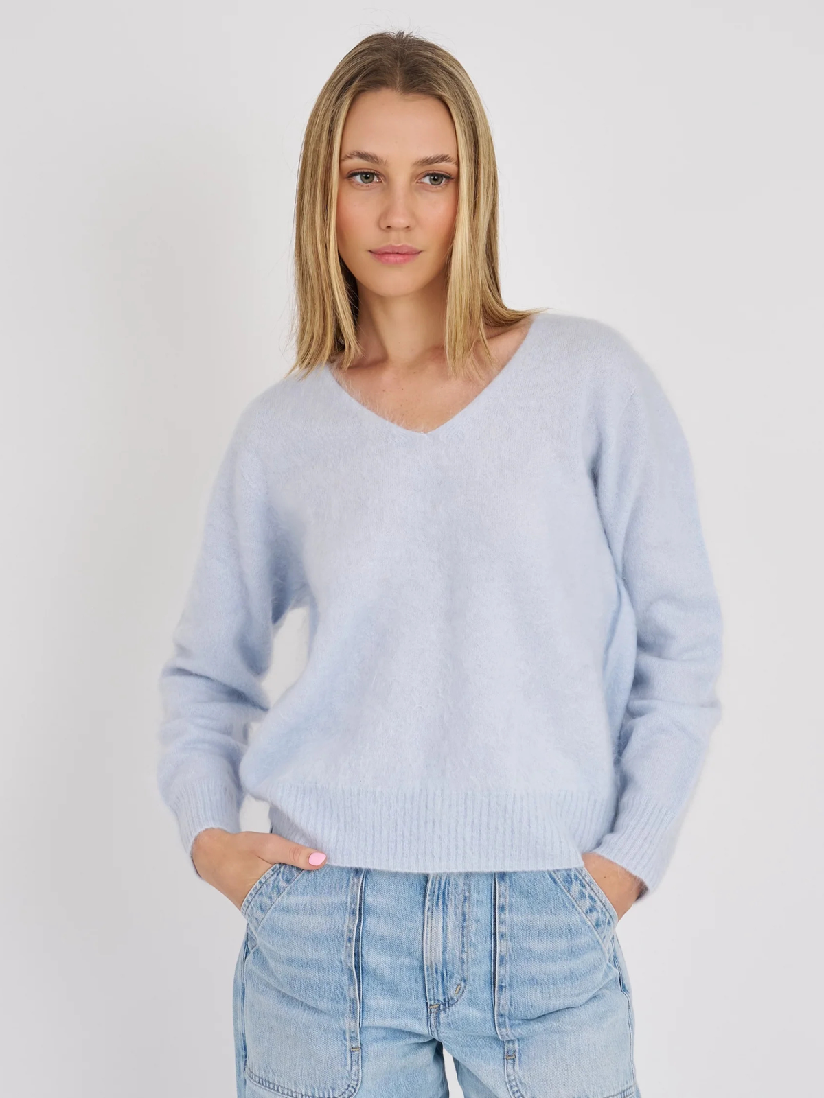 Archer Cashmere Luna sweater in icy blue, shown on a model with a V-neck and ribbed cuffs and hem.