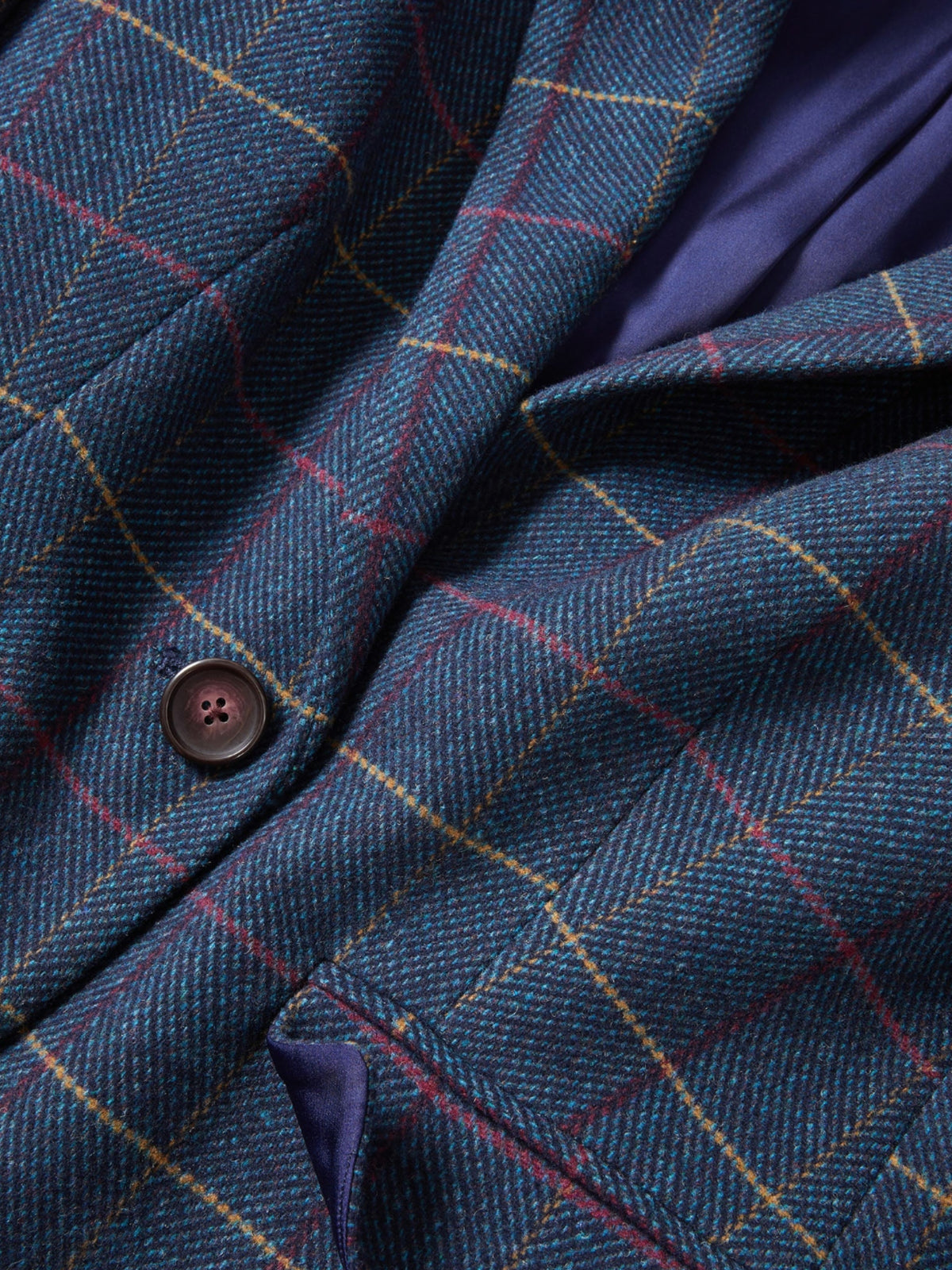 Close-up of the Veronica Beard Schoolboy Teal Multi jacket's plaid fabric, button and lining