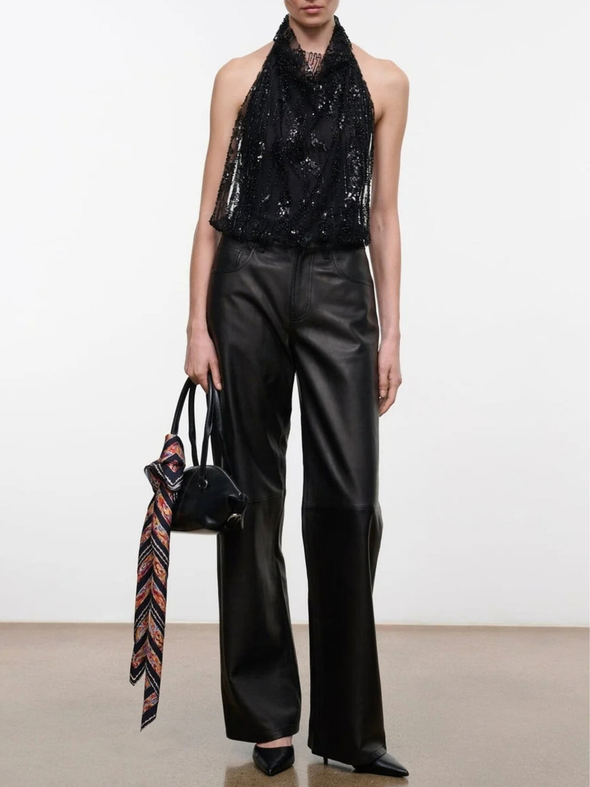 STAUD Monay Black Beaded bodysuit styled with wide-leg black pants and a handbag