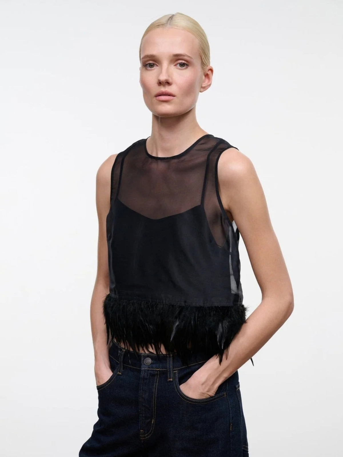 STAUD Avi Black top, close front view showing the sheer upper panel and fringed hem